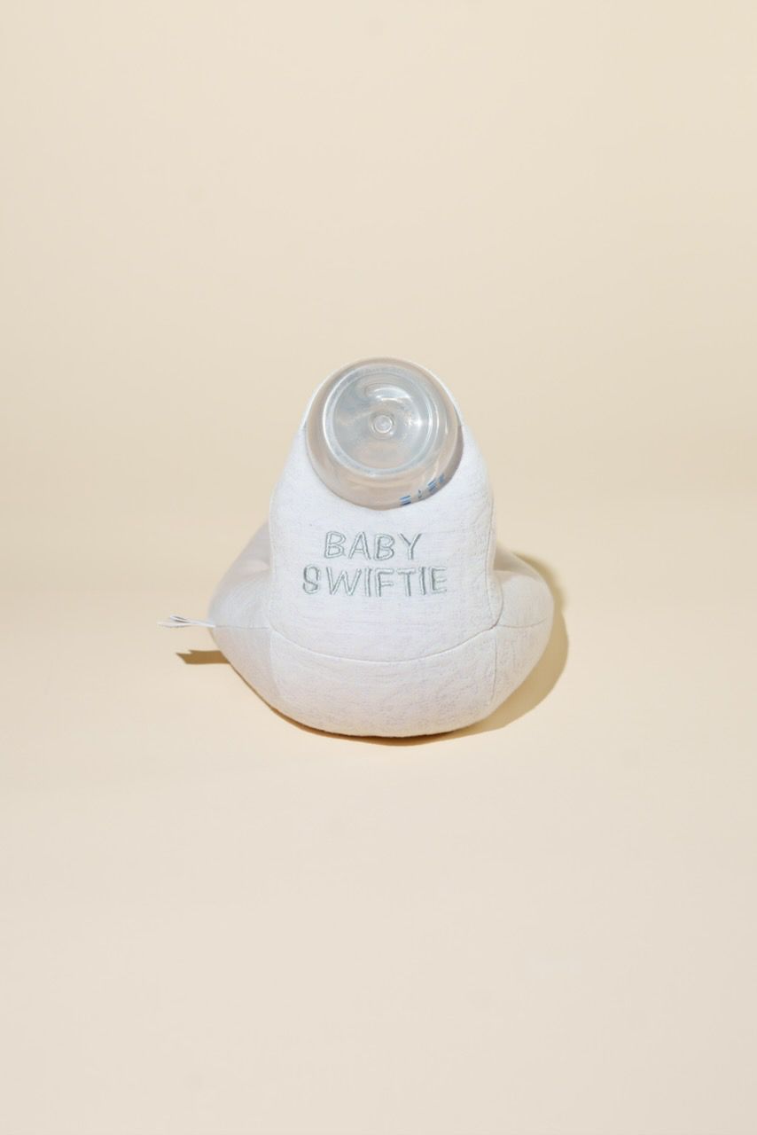 White baby bottle with 'Baby Swiftie' branding on a beige background
